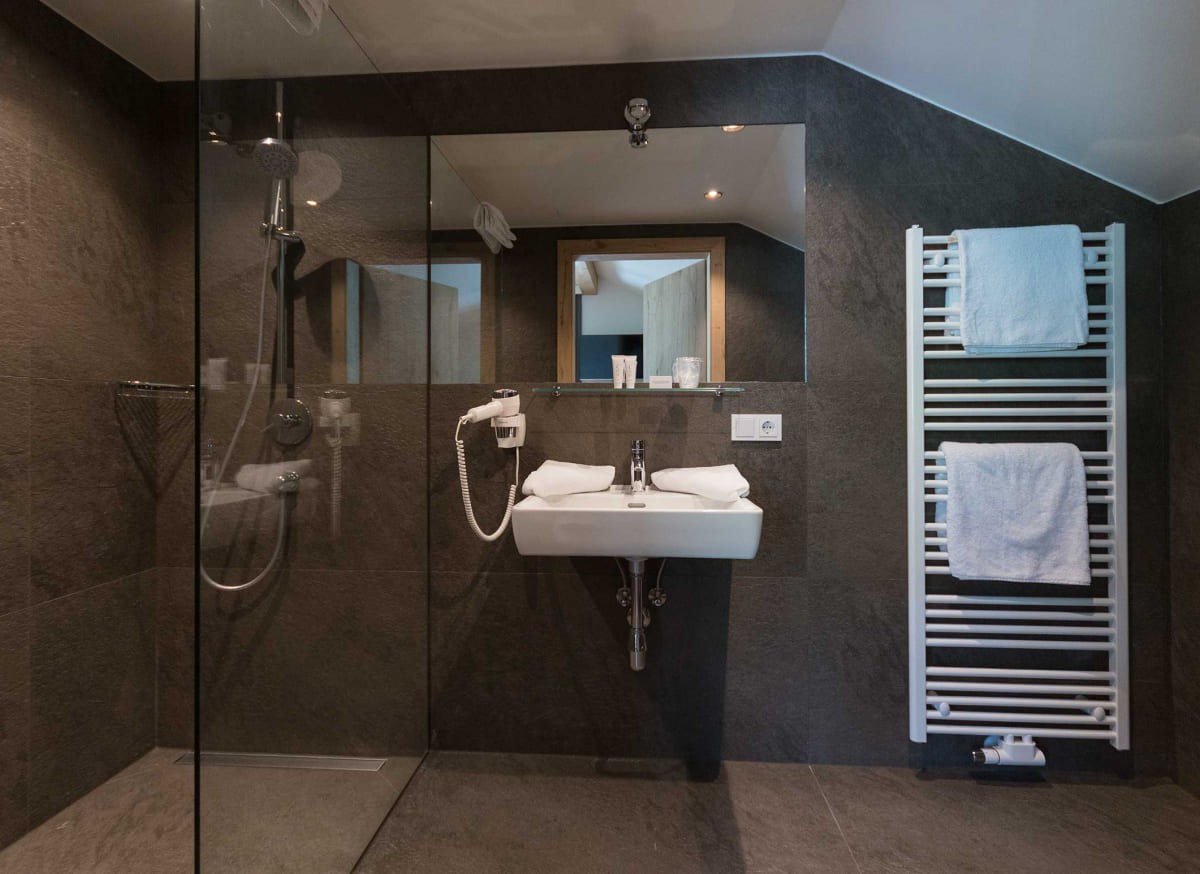 Modernes Badezimmer im Atelier Garni Astei Großarl mit Dusche, Handtüchern und stilvollem Design