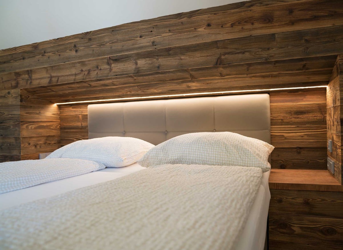 Doppelzimmer im Atelier Garni Astei in Großarl mit Holzdesign und modernem Bett