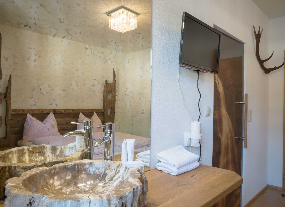 Individuell gestaltetes Zimmer im Atelier Garni Astei Großarl mit Doppelbett und stilvoller Einrichtung