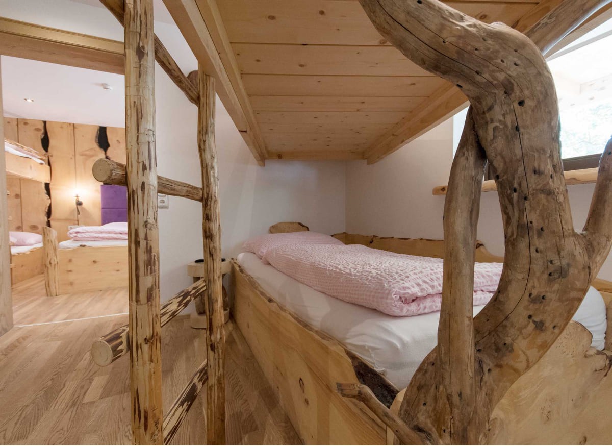 Familienzimmer im Atelier Garni Astei Großarl mit Doppelbett und zusätzlichem Schlafbereich
