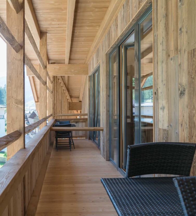 Holzbalkon mit Sitzmöbeln im Atelier Garni Astei Großarl mit Blick auf die Berge