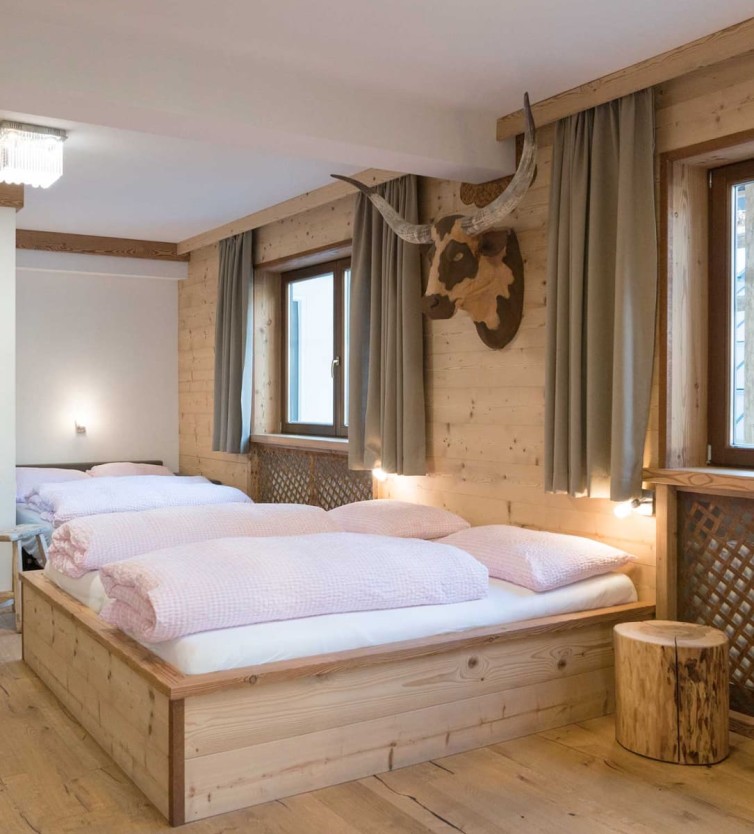Gemütliches Doppelzimmer im Atelier Garni Astei Großarl mit Holzwänden und alpinem Flair