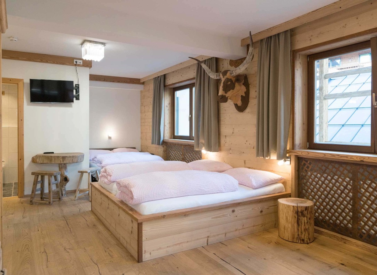Ger&auml;umiges Schlafzimmer im Gr&szlig;arltal mit Holzkunst vom Atelier Garni Astei.